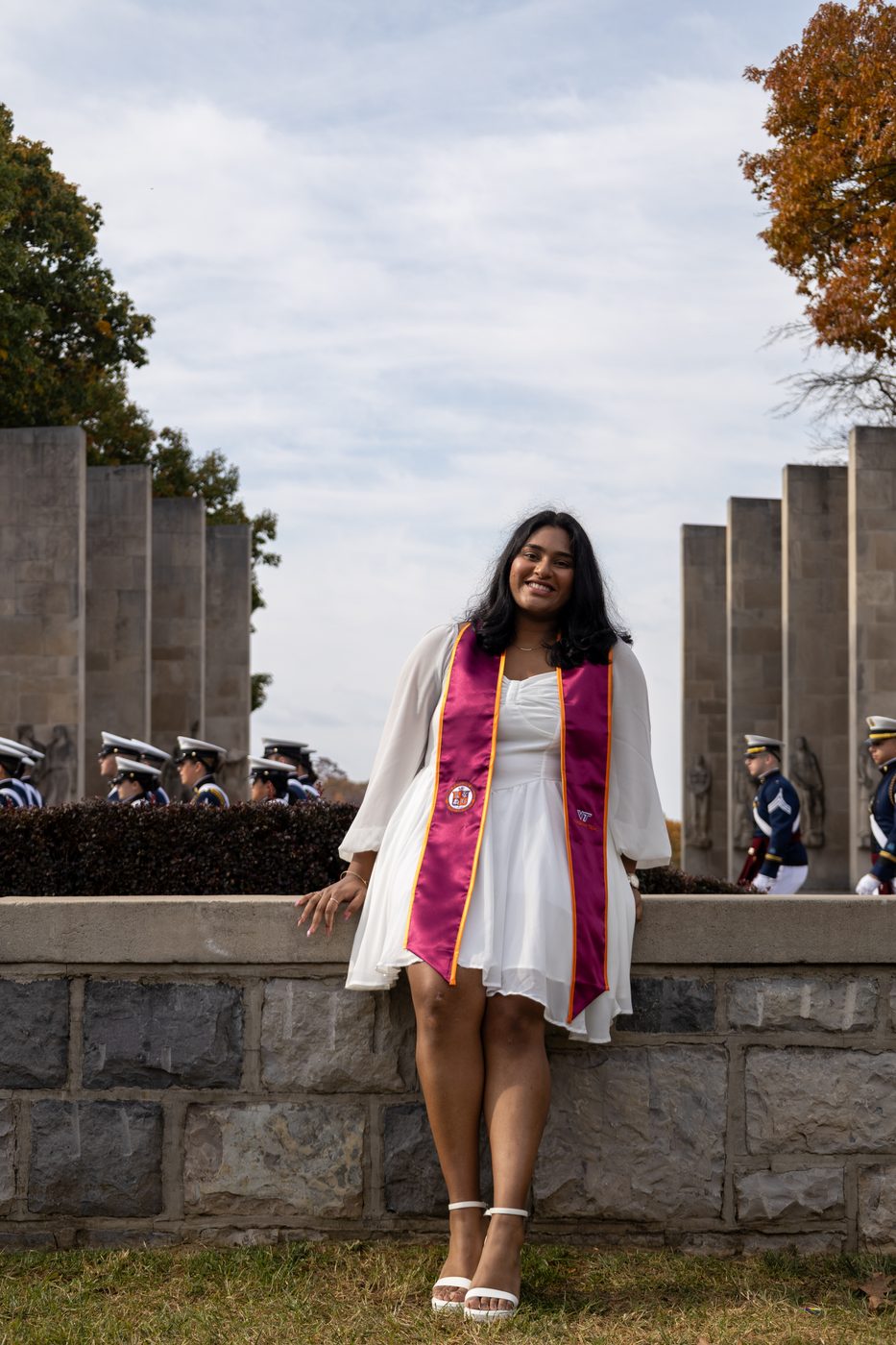 Graduate leaning against memorial pylon