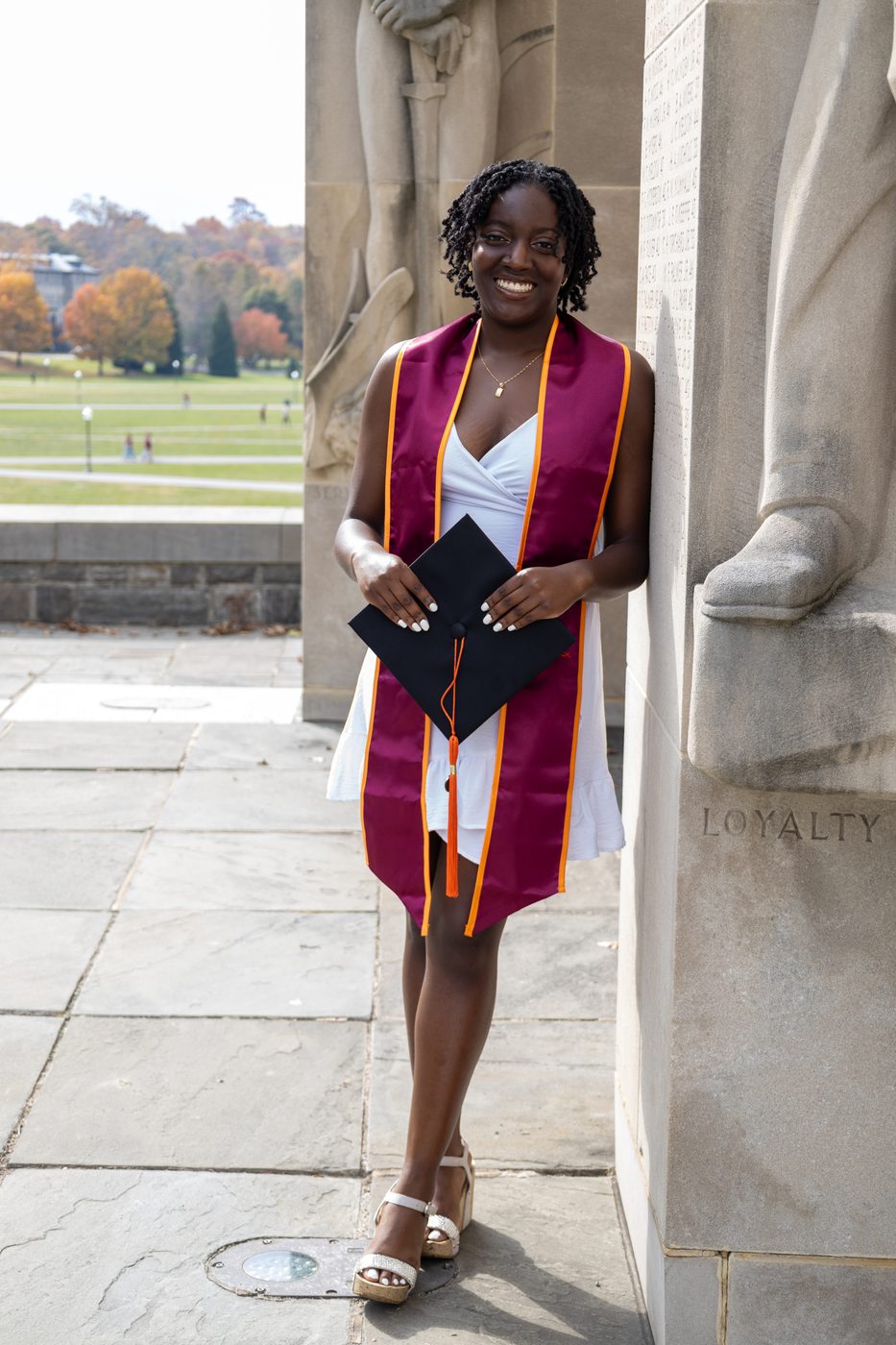 Graduate holding her cap at the memorial