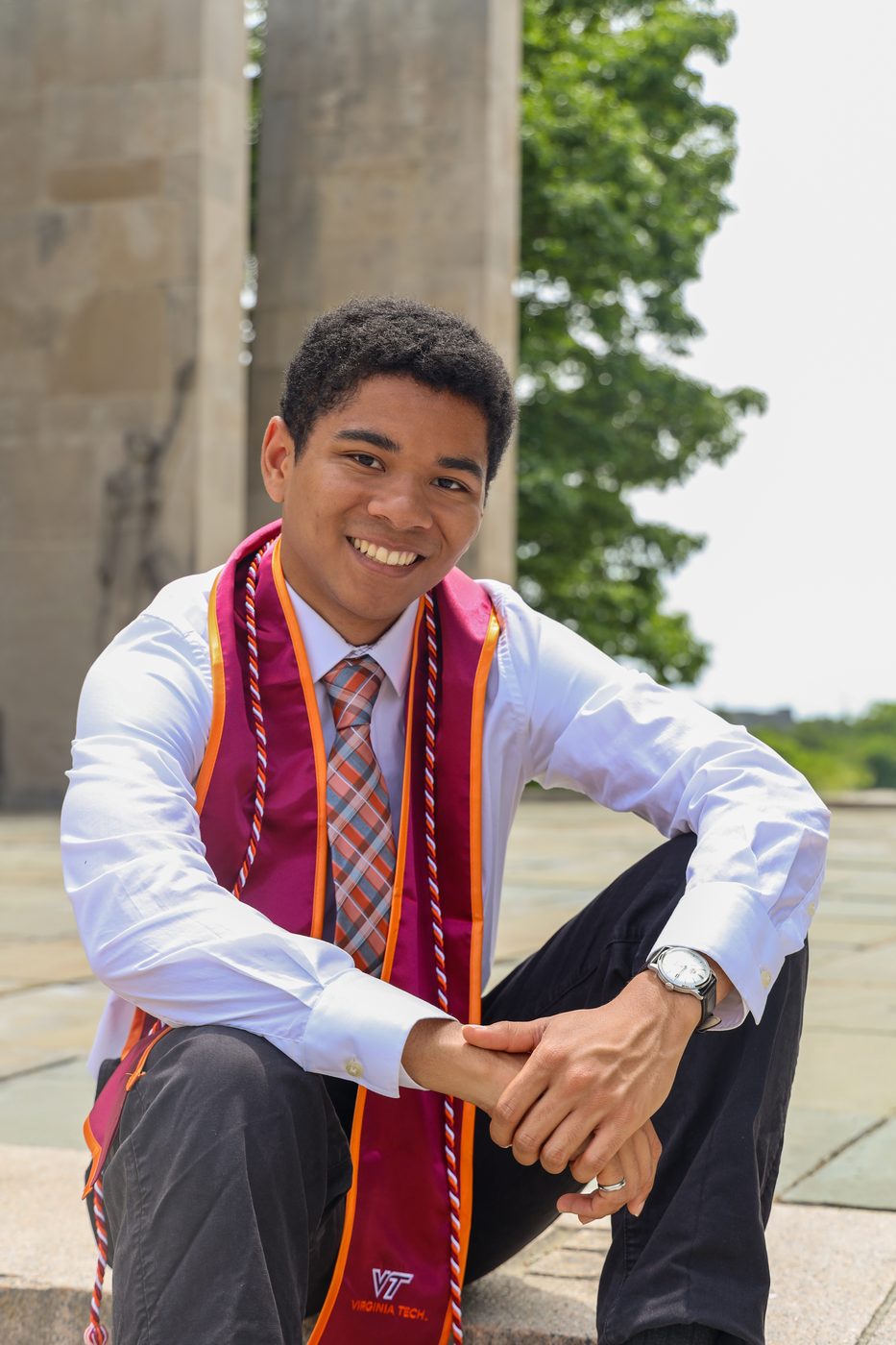 Graduate seated on memorial steps